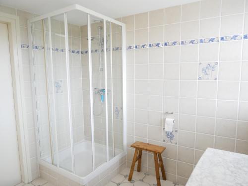 a shower in a bathroom with white tiles at Buitenplaats Villa Deluxe in Callantsoog