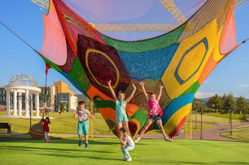 a group of children playing with a large kite at Park & Spa Hotel Markovo in Plovdiv