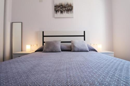 a bedroom with a large bed with two lamps at Costa Blanca Bungalow Lago jardin frente piscina 4 personas #PRP001 by Stay Orihuela Costa in Torrevieja