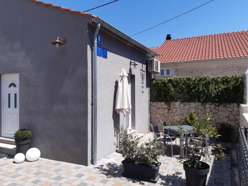 a white building with a table and a umbrella on it at Holiday Home Don in Zadar