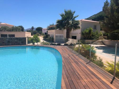 una piscina en una terraza de madera junto a una casa en Manureva Calvi, en Calvi