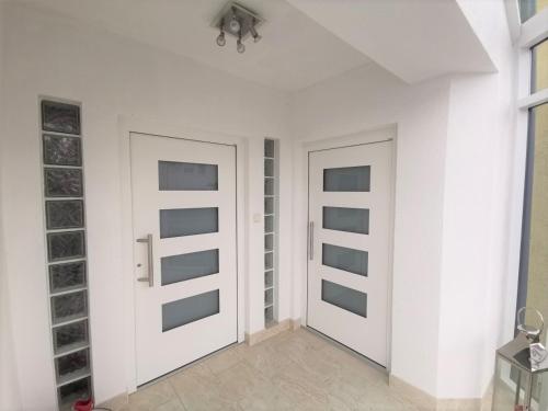 dwa drzwi w pokoju z białymi ścianami w obiekcie LieblingsOrt w mieście Neusiedl am See