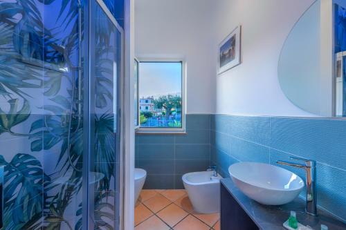 a bathroom with a sink and a toilet and a window at La Risacca Relais in Belvedere Marittimo