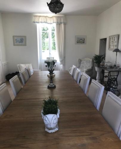 een grote houten tafel met een vaas erop bij Le Four à Pain in Saint-Jean-dʼAngély