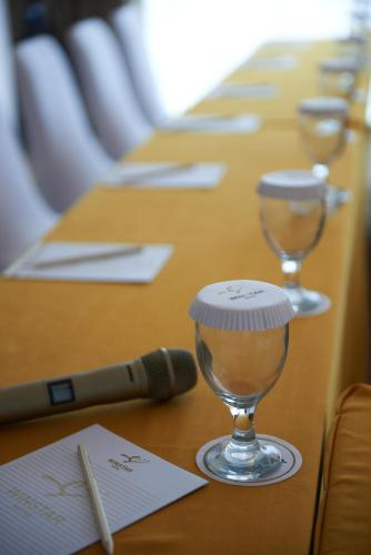 a row of tables with wine glasses and a microphone at Winstar Hotel in Pekanbaru