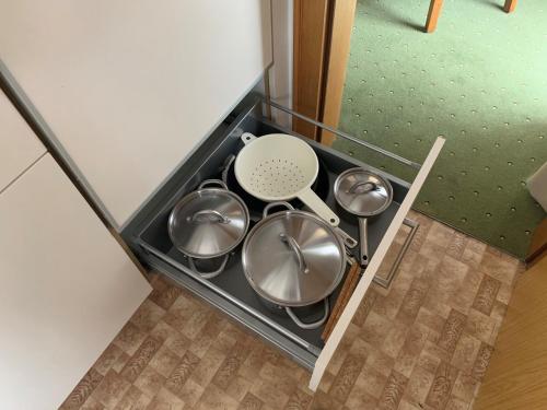 a stove top with four pots and pans at Appartement Alpenhof Wildschönau in Niederau