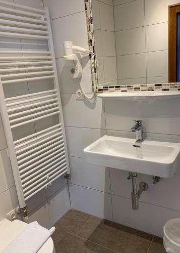 a white bathroom with a sink and a mirror at Appartement Alpenhof Wildschönau in Niederau