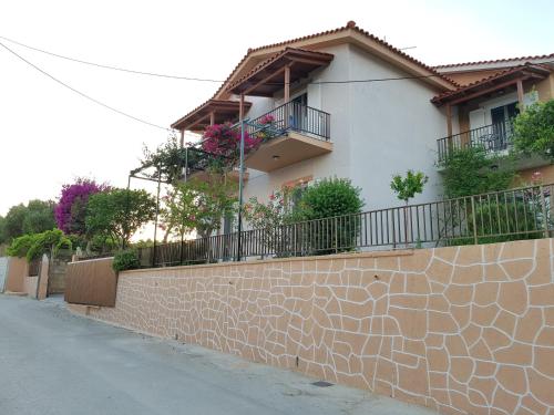 a house with balconies and a brick wall at Filippos Apartments "Apartment 2" in Spartia