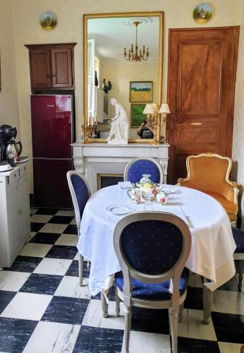 a dining room with a table and chairs and a mirror at Royal Hubert in Provins