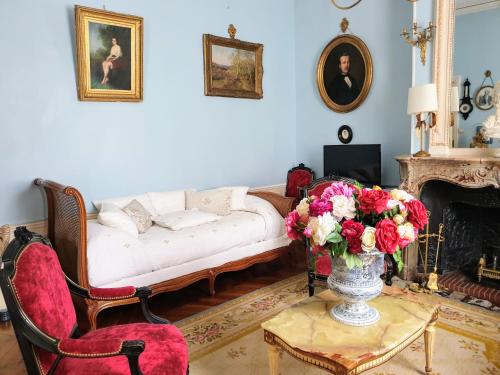 a living room with a couch and a vase of flowers at Royal Hubert in Provins