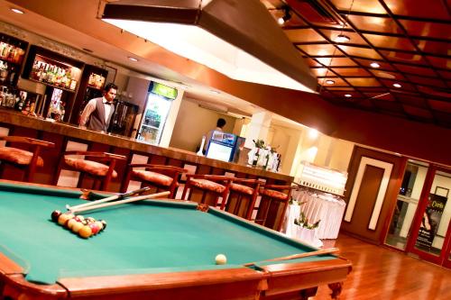a man standing behind a pool table in a bar at Grand Oriental Hotel in Colombo