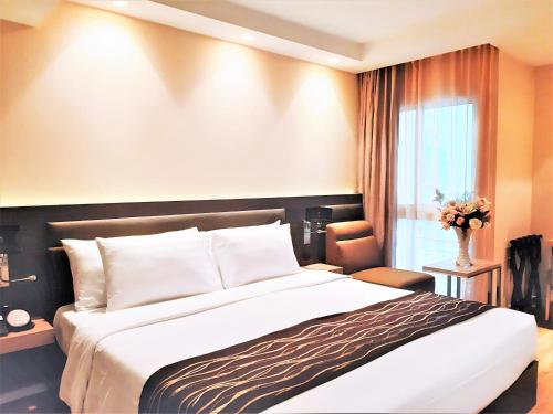 sypialnia z dużym łóżkiem i oknem w obiekcie Amora NeoLuxe Suites Hotel w mieście Bangkok