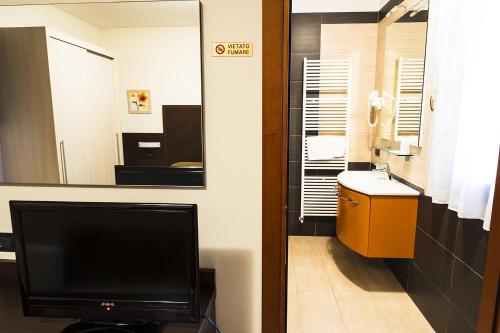 a bathroom with a tv and a bathroom with a mirror at B&B Villalta in Treviso