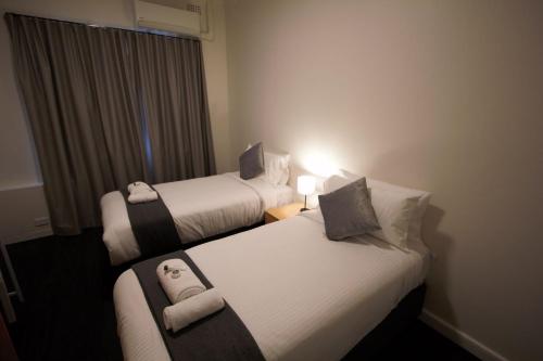 a hotel room with two beds and a window at Sydney Junction Hotel in Hamilton