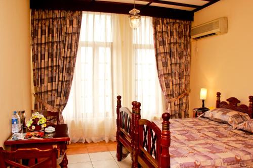 Postel nebo postele na pokoji v ubytování Grand Oriental Hotel