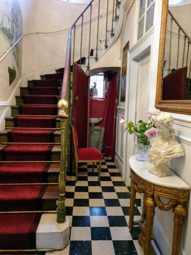a hallway with a staircase with a red and black checkered floor at Royal Hubert in Provins