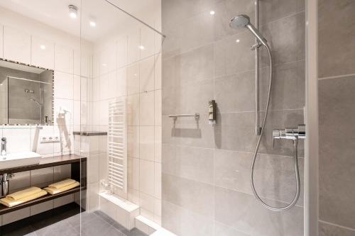 W łazience znajduje się prysznic i umywalka. w obiekcie Hotel Vollmann w mieście Weilheim in Oberbayern