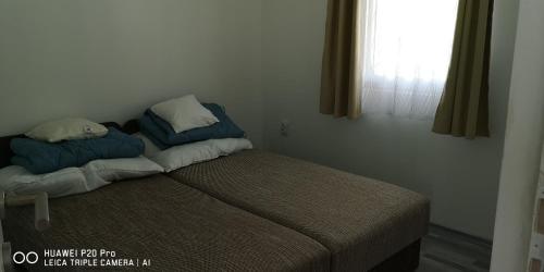 a bed with two pillows on it in a bedroom at Rákóczi Vendégház in Poroszló