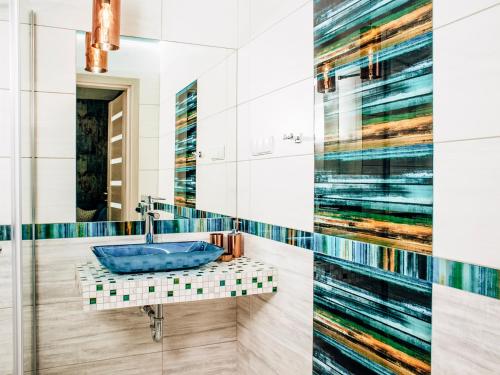 a bathroom with a blue sink and a mirror at Kaszubskie Zacisze in Władysławowo