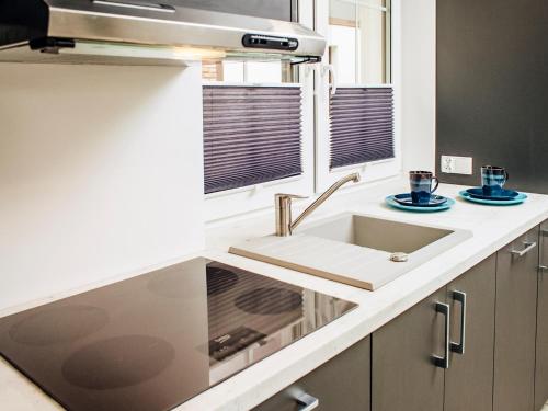 a white kitchen with a sink and a window at Kaszubskie Zacisze in Władysławowo