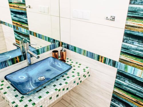 a bathroom with a blue sink on a tiled floor at Kaszubskie Zacisze in Władysławowo