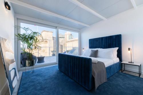 um quarto com uma cama grande e uma janela grande em U Collection - a Luxury Collection Suites, Valletta em Valeta