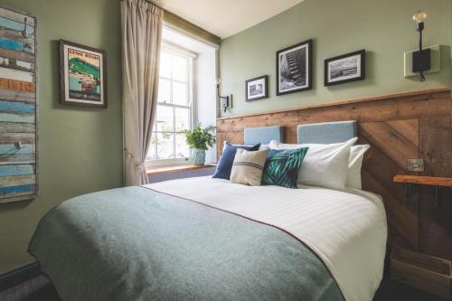 
a bedroom with a large bed and a large window at Rock Point Inn in Lyme Regis
