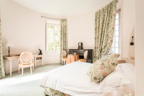 a room with a bed, chair, table and window at Hôtel Chateau Golf des Sept Tours by Popinns in Courcelles-de-Touraine