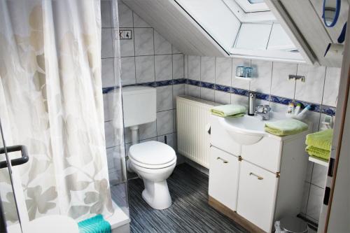 a bathroom with a toilet and a sink at Gästehaus Marek in Nordenham