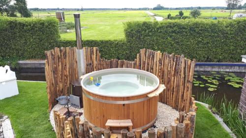 a hot tub in a garden with a wooden fence at Villa Pura Vida in Oud-Ade