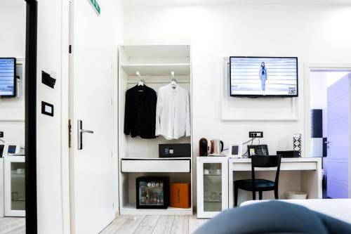 a room with a closet with a desk and a tv at Escape Luxury Suite in Rome