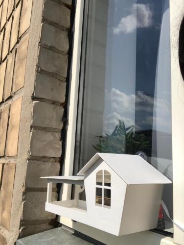a white toy house sitting on a window sill at Birdie Home at Nauky metro in Kharkiv