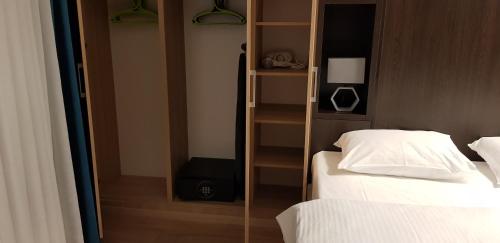 a room with two beds and a glass wall with a book shelf at Metropolis Apartamenty Centrum in Kalisz