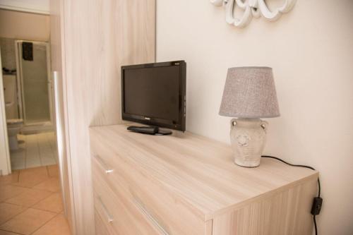 una televisione e una lampada seduti su un tavolo di legno di Enjoy Bologna Apartment a Bologna