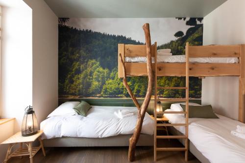 科爾馬的住宿－Appartement A Travers Champs avec Sauna et Parking，墙上画作的房间里设有两张双层床