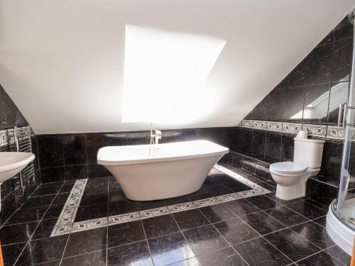 een badkamer met een bad, een toilet en een wastafel bij Bryn Awel in Denbigh