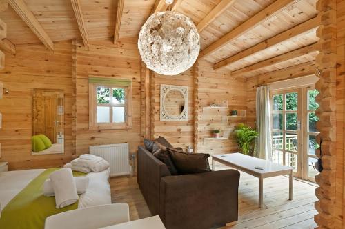 Habitación de madera con cama y lámpara de araña. en The Lodge with hot tub, en Maidstone
