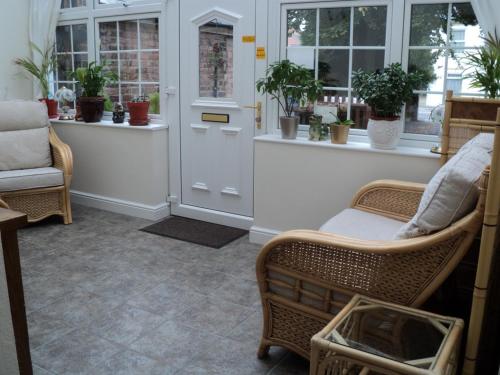 a room with two chairs and a door with windows at Grove House Guest House in Telford