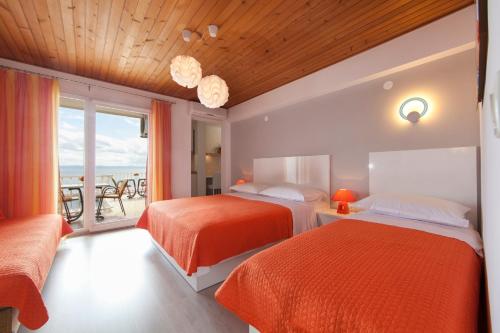 a hotel room with two beds and a balcony at Apartments Milana in Tučepi