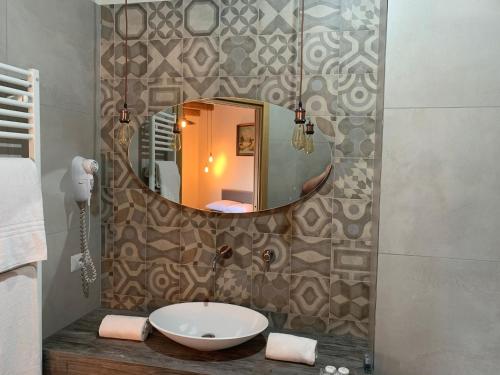 a bathroom with a sink and a mirror on a wall at Vecchia Posta B&B in Montecatini Terme