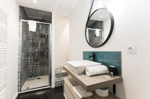 een badkamer met een wastafel en een spiegel bij Appartement spacieux et lumineux avec climatisation Halle 1ER in Castillon-la-Bataille