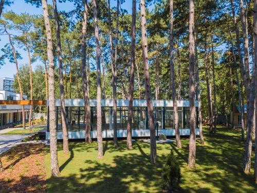 an office building with trees in front of it at Szent Bernadett Családi Apartmanház in Siófok