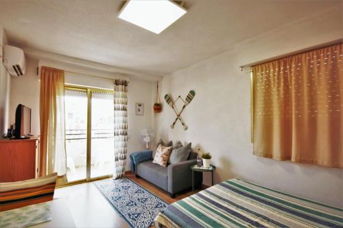 a bedroom with a bed and a couch and a window at Estudio Gran Playa in Santa Pola