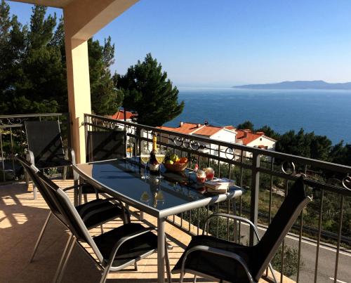 a table on a balcony with a view of the ocean at VILA MARIJA in Mimice