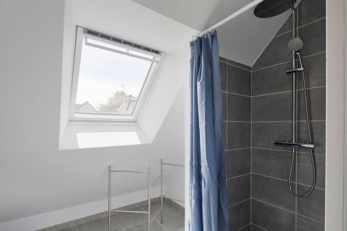 a bathroom with a shower with a blue shower curtain at La Garde & Le Repos - Proche plage St Lunaire in Saint-Lunaire
