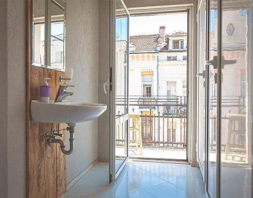 a bathroom with a sink and a large window at Temple House in Plovdiv