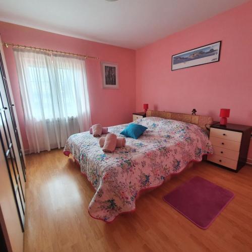 a bedroom with pink walls and a bed and a dresser at Apartments Piglić in Lovran
