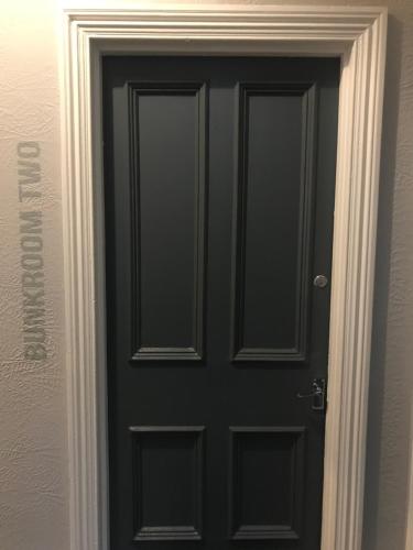 a black door with a white frame in a room at Newcastle House Rothbury in Rothbury