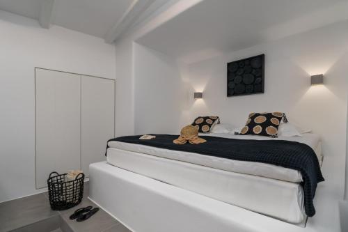ein weißes Schlafzimmer mit einem Bett mit einem Teddybär darauf in der Unterkunft Peter's Sea and Sαnd Residence in Adamas