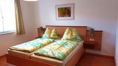 ein Schlafzimmer mit einem Bett mit zwei Kissen darauf in der Unterkunft Gästehaus Familie Trachsler in Rohrendorf bei Krems
